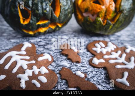 Halloween-Kekse und ausgeschnittene Kürbisse auf grauem Hintergrund. Stockfoto