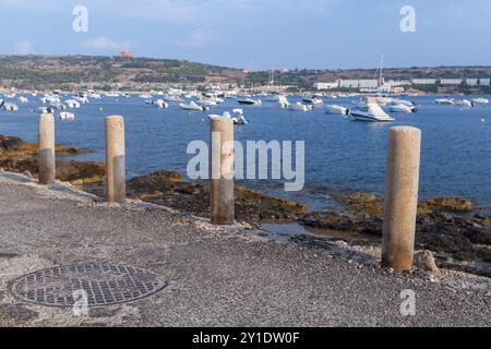 Küstenlandschaft von Mellieha mit Steinsäulen und verankerten Booten. Es ist eine kleine Stadt in der nördlichen Region Maltas Stockfoto