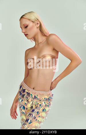 Eine junge Frau im Metallic-Outfit strahlt Selbstvertrauen und modernen Stil aus. Stockfoto