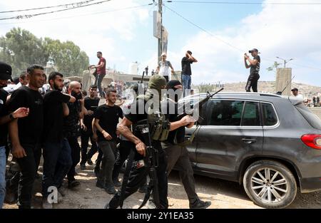 Jenin, Westjordanland, Palästina. September 2024. Bewaffnete palästinensische Militanten bei einer großen Beerdigung junger Palästinenser, die von israelischen Truppen im Flüchtlingslager Dschenin im nördlichen Westjordanland getötet wurden. Die israelischen Streitkräfte haben sich nach einer zehntägigen intensiven Militäroffensive aus der Stadt Dschenin und ihren Flüchtlingslagern zurückgezogen. Der lange israelische Angriff hat zum Tod von 21 Palästinensern geführt und weit verbreitete Zerstörungen und Schäden hinterlassen, einschließlich der Wasser- und Abwasserinfrastruktur Stockfoto