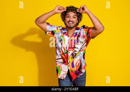 Porträt des netten jungen Mannes berühren Sonnenbrille Wear Hemd isoliert auf gelbem Hintergrund Stockfoto