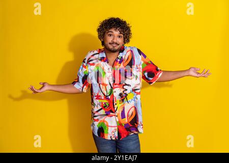 Foto des netten jungen Mannes mit den Schultern tragen Hemd isoliert auf gelbem Hintergrund Stockfoto