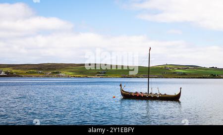 Lerwick, Shetland - 12. Juli 2024: Blick in Richtung Bressay Island auf einem Wikinger-Langboot namens Dim-Riv, das im Wasser vor Lerwick sitzt. Stockfoto