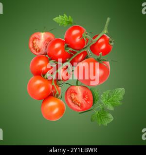 Frische Tomaten mit Blättern in der Luft auf grünem Hintergrund Stockfoto