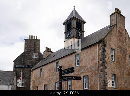 Lerwick, Shetland - 12. Juli 2024: Das Old Tolbooth Gefängnisgebäude mit Uhrturm und Blick auf das Queen's Hotel dahinter. Stockfoto