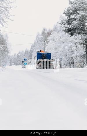 Blauer Truck fährt die vereiste Straße in Rovaniemi, Lappland im schneebedeckten Winter hinunter Stockfoto