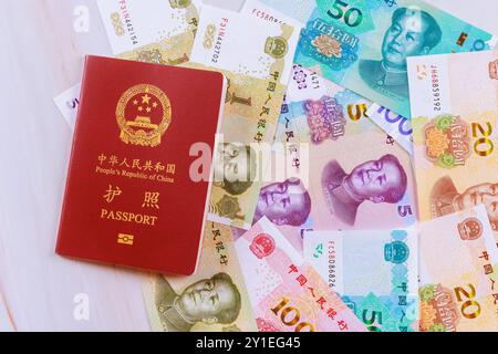 Authentischer Pass der Volksrepublik China mit chinesischen Yuan-Banknoten in verschiedenen Stückelungen Stockfoto