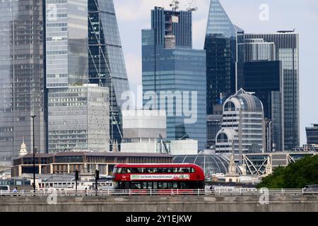 Ein New Routemaster Doppeldeckerbus, auch bekannt als Boris Bus, überquert die Waterloo Bridge über die Themse mit den Wolkenkratzern der Stadt Lon Stockfoto