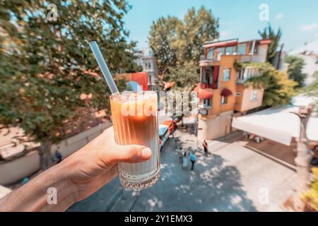Ein erfrischender Eiskaffee in der Hand in einem Dachcafé, perfekt für einen Sommerurlaub-Drink Stockfoto