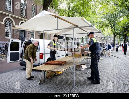 AMSTERDAM - Polizeibeamte helfen, einen Buchmarkt auf dem Spui zu räumen, bevor propalästinensische Aktivisten in Maagdenhuis der Universität Amsterdam (UVA) ankamen. Die Demonstranten sind gegen die Zusammenarbeit der UVA mit israelischen akademischen Einrichtungen. ANP SEM VAN DER WAL niederlande Out - belgien Out Credit: ANP/Alamy Live News Stockfoto