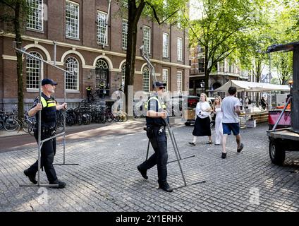 AMSTERDAM - Polizeibeamte helfen, einen Buchmarkt auf dem Spui zu räumen, bevor propalästinensische Aktivisten in Maagdenhuis der Universität Amsterdam (UVA) ankamen. Die Demonstranten sind gegen die Zusammenarbeit der UVA mit israelischen akademischen Einrichtungen. ANP SEM VAN DER WAL niederlande Out - belgien Out Credit: ANP/Alamy Live News Stockfoto