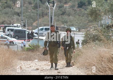 Israelische Truppen und Polizisten versammeln sich an einer Bushaltestelle in der Nähe der israelischen Siedlung Ariel, neben der Stadt Salfit, wo ein palästinensischer Jugendlicher versuchte, einen Soldaten zu erstechen, bevor er von anderen Soldaten erschossen und getötet wurde. Während der letzten Woche waren die Spannungen zwischen israelischen Siedlern und Palästinensern hoch: Eine 45-jährige Palästinenserin wurde am vergangenen Freitag von israelischen Siedlern getötet, die in der Nähe des Zaatara-Kontrollpunkts in Nablus Steine auf ihr Fahrzeug schleuderten. Der Ort des Vorfalls befand sich in der Nähe des Industriegebiets von Barkan, wo ein palästinensischer Mann zwei israelische Mitarbeiter tötete und acht Tage lang eine weitere Frau verletzte Stockfoto