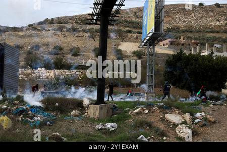 Palästinensische Demonstranten stoßen am 2. Dezember 2018 bei einer Kundgebung für Jerusalem in der Nähe der Westjordanstadt Nablus mit den israelischen Streitkräften zusammen. Palästinensische Demonstranten waren zum Hawara-Kontrollpunkt im Süden von Nablus marschiert, um gegen die jüngsten israelischen Verstöße in Ost-Jerusalem zu protestieren. Israelische Soldaten feuerten Tränengas und Gummigeschosse auf Demonstranten, die Steine auf sie schleuderten. Mehrere Demonstranten, darunter auch Pressevertreter, waren von Tränengas betroffen Stockfoto