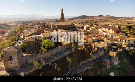 Blick aus der Vogelperspektive auf Briones, eine kleine mittelalterliche Stadt auf einem Hügel. Die Stadtmauer, Häuser und die majestätische Kirche. Briones, La Rioja, Spanien. Stockfoto