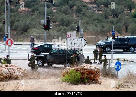 Israelische Truppen und Polizisten versammeln sich an einer Bushaltestelle in der Nähe der israelischen Siedlung Ariel, neben der Stadt Salfit, wo ein palästinensischer Jugendlicher versuchte, einen Soldaten zu erstechen, bevor er von anderen Soldaten erschossen und getötet wurde. Während der letzten Woche waren die Spannungen zwischen israelischen Siedlern und Palästinensern hoch: Eine 45-jährige Palästinenserin wurde am vergangenen Freitag von israelischen Siedlern getötet, die in der Nähe des Zaatara-Kontrollpunkts in Nablus Steine auf ihr Fahrzeug schleuderten. Der Ort des Vorfalls befand sich in der Nähe des Industriegebiets von Barkan, wo ein palästinensischer Mann zwei israelische Mitarbeiter tötete und acht Tage lang eine weitere Frau verletzte Stockfoto