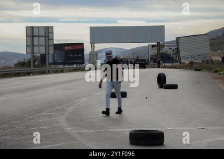 Palästinensische Demonstranten stoßen am 2. Dezember 2018 bei einer Kundgebung für Jerusalem in der Nähe der Westjordanstadt Nablus mit den israelischen Streitkräften zusammen. Palästinensische Demonstranten waren zum Hawara-Kontrollpunkt im Süden von Nablus marschiert, um gegen die jüngsten israelischen Verstöße in Ost-Jerusalem zu protestieren. Israelische Soldaten feuerten Tränengas und Gummigeschosse auf Demonstranten, die Steine auf sie schleuderten. Mehrere Demonstranten, darunter auch Pressevertreter, waren von Tränengas betroffen Stockfoto