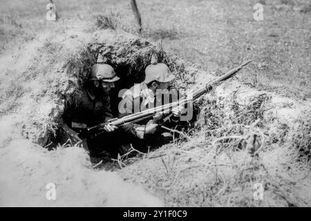 Zwei deutsche Landsturmsoldaten aus dem 1. Weltkrieg 1916 mit Pickelhaube, Stachelhelmen im Foxhole/Dugout auf dem Schlachtfeld des Ersten Weltkriegs in Nordfrankreich Stockfoto