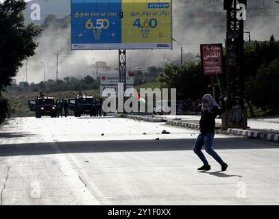 Palästinensische Demonstranten stoßen am 2. Dezember 2018 bei einer Kundgebung für Jerusalem in der Nähe der Westjordanstadt Nablus mit den israelischen Streitkräften zusammen. Palästinensische Demonstranten waren zum Hawara-Kontrollpunkt im Süden von Nablus marschiert, um gegen die jüngsten israelischen Verstöße in Ost-Jerusalem zu protestieren. Israelische Soldaten feuerten Tränengas und Gummigeschosse auf Demonstranten, die Steine auf sie schleuderten. Mehrere Demonstranten, darunter auch Pressevertreter, waren von Tränengas betroffen Stockfoto
