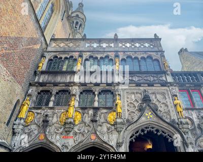 Brügge, Flandern, Belgien - 25. Juni 2024: Fassade der Basilika des Heiligen Blutes mit ihren goldenen Statuen auf dem Burgplatz. Kombination von Gothic und R Stockfoto