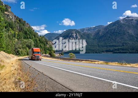 Braune Sattelzugmaschine mit großem Lkw für den industriellen Einsatz mit verlängerter Kabine für den Transport von Gütern im trockenen Lieferwagen mit Auflieger Stockfoto