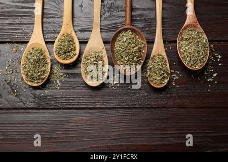 Getrockneter Oregano in Löffeln auf Holztisch, flach gelegt Stockfoto
