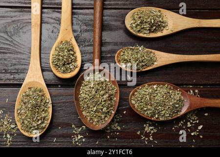 Getrockneter Oregano in Löffeln auf Holztisch, flach gelegt Stockfoto