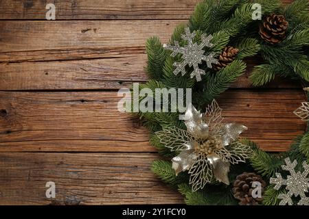 Weihnachtskranz mit Kegeln und dekorativen Schneeflocken auf Holztisch, Blick von oben. Leerzeichen für Text Stockfoto