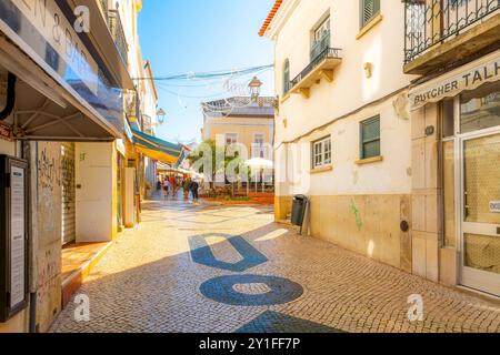 Eine malerische Straße mit traditionellen portugiesischen Straßenmustern und Straßencafés in Lagos, Portugal, Algarve. Stockfoto