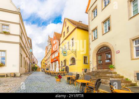 Eine farbenfrohe Kopfsteinpflasterstraße entlang des Marktplatzes mit Geschäften und Straßencafés im mittelalterlichen Dorf. Stockfoto