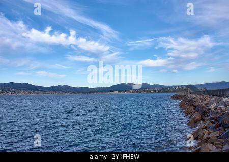 Atemberaubende Aussicht vom Strand Barbeira in Bayona, Pontevedra, Spanien. Das Bild zeigt einen zerklüfteten Wellenbrecher, der von Felsen gesäumt ist und sich in die Ruhe ausdehnt Stockfoto