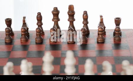 Schachfiguren an Bord mit weißem Hintergrund Stockfoto