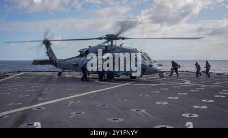 [240903-N-HV010-1041] Seemänner der US-Marine sichern mit Keilen und Ketten eine MH-60S Seahawk, die an der Helicopter Sea Combat Squadron (HSC) 23 befestigt ist, am Flugdeck des amphibischen Dock-Landungsschiffes USS Harpers Ferry (LSD 49) während der Durchführung von Flugoperationen im Rahmen der Übung Ssang Yong 24 vor der Küste von Pohang, Südkorea, 3. September 2024. Übung SY24 stärkt die Republik Korea-USA Allianz durch bilaterale, gemeinsame Ausbildung, die zu kombinierten amphibischen Fähigkeiten zur Verteidigung der koreanischen Halbinsel beiträgt. (Foto der US Navy von Mass Communication Specialist 2nd Class sang Ki Stockfoto