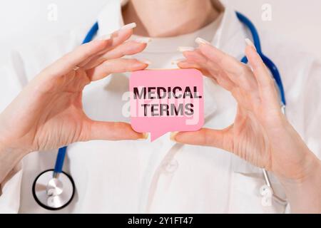 Arzt, der eine Karte mit medizinischen BEGRIFFEN in der Hand hält Stockfoto