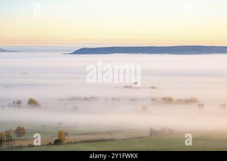 Morgennebel über einer ländlichen Landschaft im Herbst mit einem Berg, der sich aus dem Nebel am Horizont erhebt Stockfoto