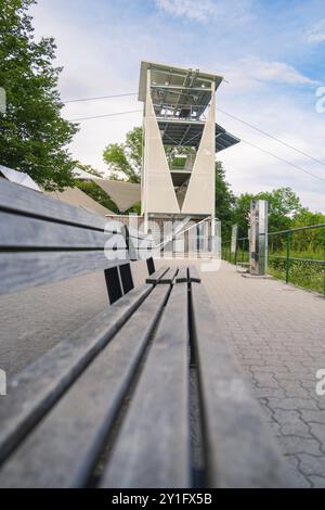 Eine lange Holzbank führt entlang eines Wanderweges mit Blick auf einen modernen Aussichtsturm, Rappbodetalsperre, Harz, Deutschland, Europa Stockfoto