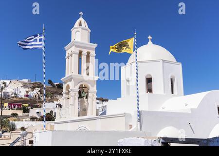 Kirche und Glockenturm in typisch griechischem Stil in Santorin mit griechischer Flagge und gelber Doppeladlerflagge in der Kirche St. Theodosias in Pyr Stockfoto