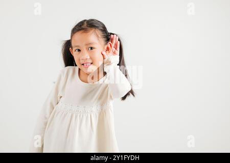 Portrait Asiatisches kleines Kind lächelnd hörend hörend Tratsch mit Aufmerksamkeit mit der Hand Stockfoto