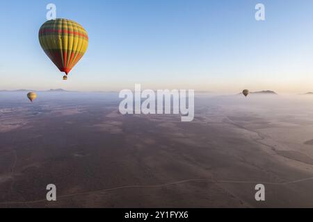 Farbenfrohe Heißluftballons, die über der riesigen marokkanischen Wüste schweben. Stockfoto