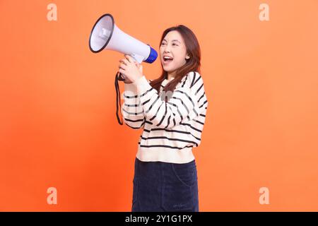indonesien Frau offen wütend schreiend Ausdruck stehend mit zwei Händen, die Megaphon-Lautsprecher halten. Für Mode, Business und Fernsehen Stockfoto