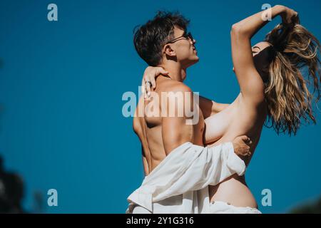Romantisches Paar, das einen sonnigen Tag im Freien in einem verspielten und intimen Moment genießt Stockfoto