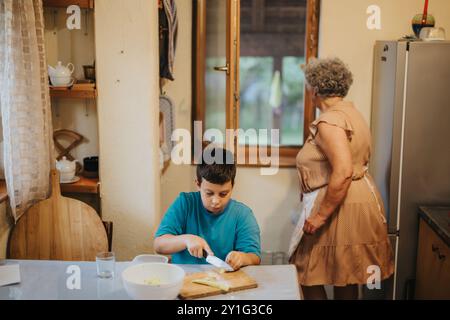 Großmutter und Enkel kochen zusammen in einer gemütlichen Küche Stockfoto