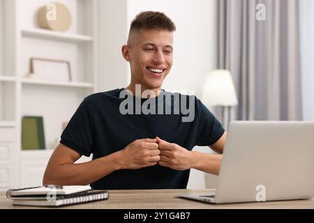 Junger Mann mit Gebärdensprache während Videogesprächen in Innenräumen Stockfoto