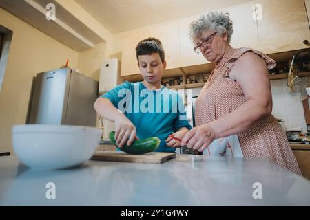 Großmutter und Enkel bereiten gemeinsam Essen in der Küche vor Stockfoto