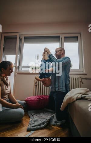 Glückliche Familie, die eine spielerische Zeit mit ihrem Kind zu Hause genießt Stockfoto