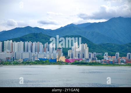 Sokcho, Südkorea - 28. Juli 2024: Die Hochhäuser von Sokcho, darunter der unverwechselbare Expo Tower, stehen hoch vor dem üppig grünen Taeb Stockfoto