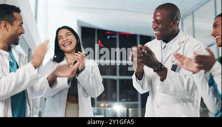 Gesundheitswesen, Team und Applaus im Krankenhaus für Erfolg, medizinischen Durchbruch und begeistert von Erfolg. Ärzte, Krankenschwestern und Feier in der Lobby für Stockfoto