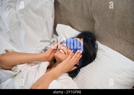 Schöne Frau liegt auf einem großen Bett im Hotelzimmer Stockfoto