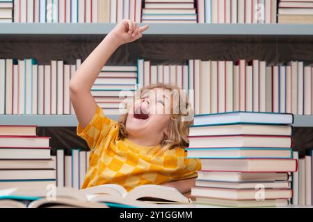 Bildungskonzept. Ein aufgeregtes Kind liest Buch in einem Buchladen oder in einer Schulbibliothek Stockfoto