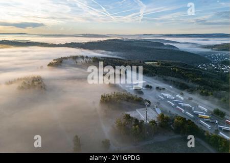 Sommermorgen im Siegerland. So langsam wird es Herbstlich. Luftaufnahme der Landschaft in der Nähe von Siegen-Oberschelden rechts. In den Taelern Tälern liegt Nebel. Im Vordergrund die Raststaette Raststätte Siegerland Ost an der Autobahn A45. Sommer im Siegerland am 07.09.2024 in Siegen/Deutschland. *** Sommermorgen in Siegerland so langsam wird es herbstlich Luftaufnahme der Landschaft bei Siegen Oberschelden direkt in den Tälern liegt Nebel im Vordergrund die Raststaette Siegerland Ost auf der Autobahn A45 Sommer in Siegerland am 07 09 2024 in Siegen Deutschland Stockfoto