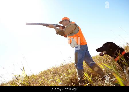 Mann, Hund und Outdoor für die Jagd nach Schrotflinte, Gewehr und Raubtier zusammen in der Natur. Unterstützung von Reifen Personen, Haustieren und Jägern vor Ort als Führer Stockfoto